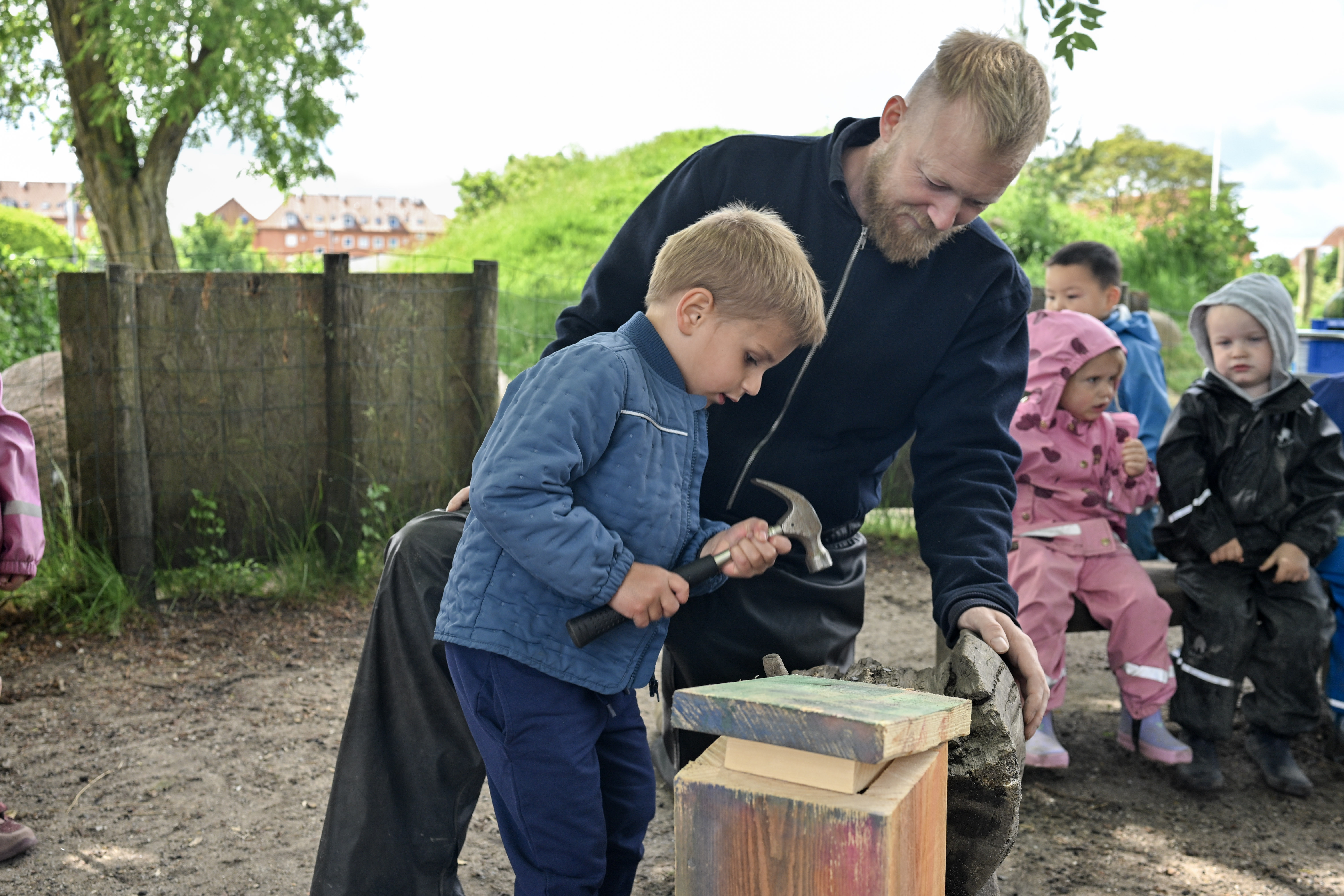 Barn med hammer sammen med voksen