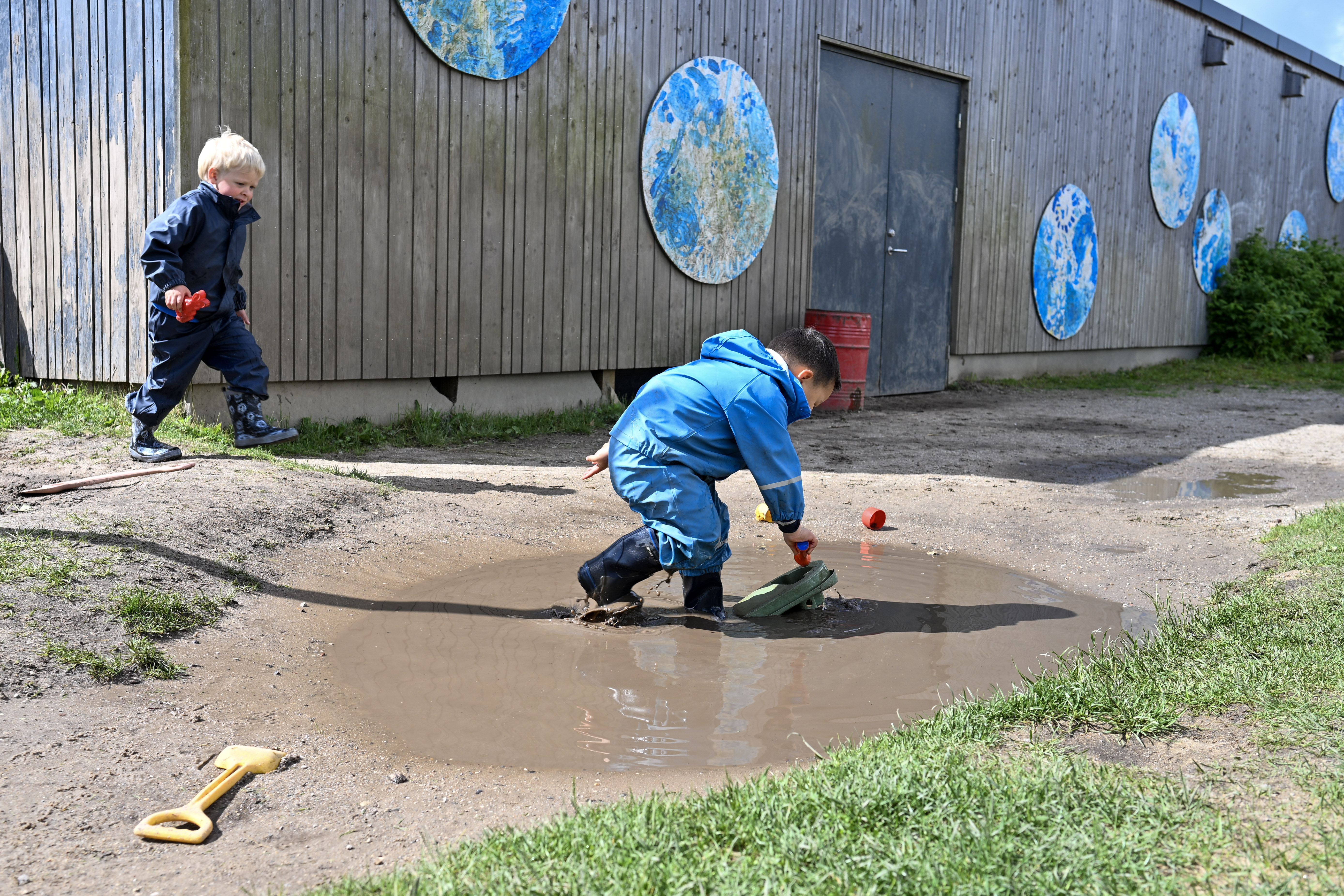 Barn leger i vandpyt