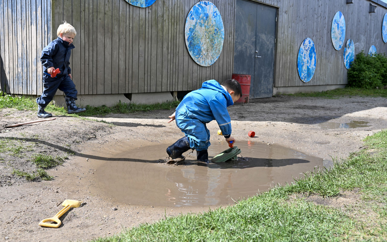 Barn leger i vandpyt